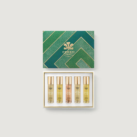 Set of Creed perfume bottles in a decorative box on a light gray background