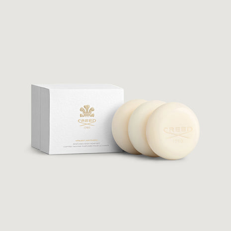 Two cream-colored soaps with a white box labeled 'Creed' on a light gray background