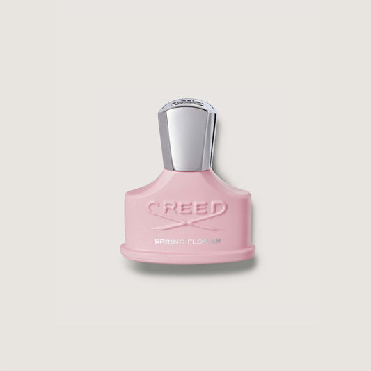 Pink Creed perfume bottle on a light gray background